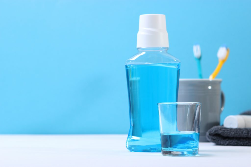 blue mint mouthwash in bottle and cup