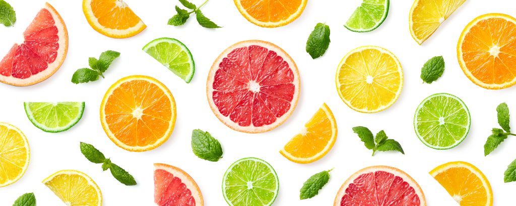 Colorful pattern of citrus fruit slices and mint leaves isolated on white background. Top view, flat lay