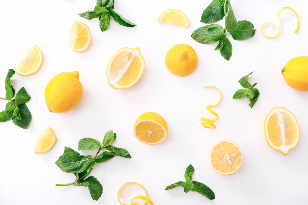 Fresh cut lemon and mint leaves on white background